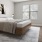 a bedroom with a bed, large window and lamps on side tables